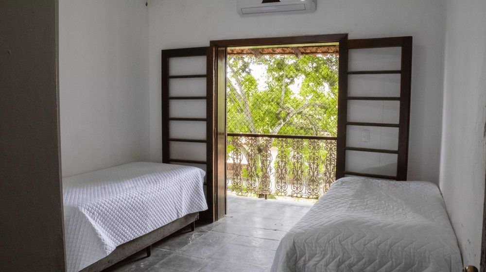Quarto arejado com varanda voltada para a área verde