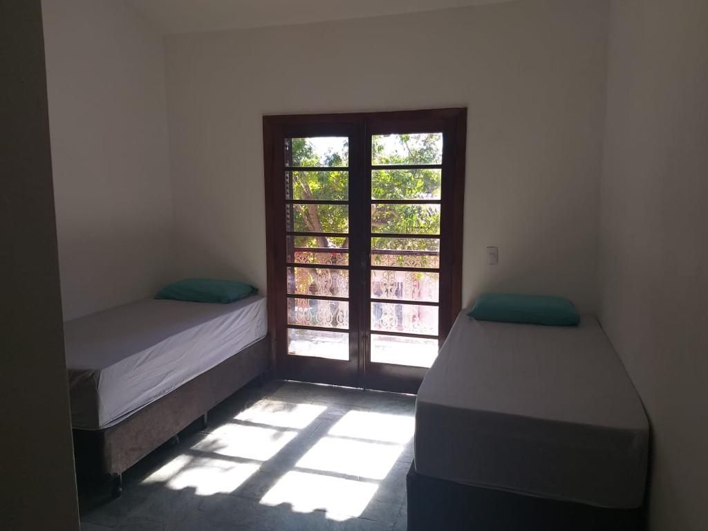 Quarto com duas camas e porta-balcão para a área verde