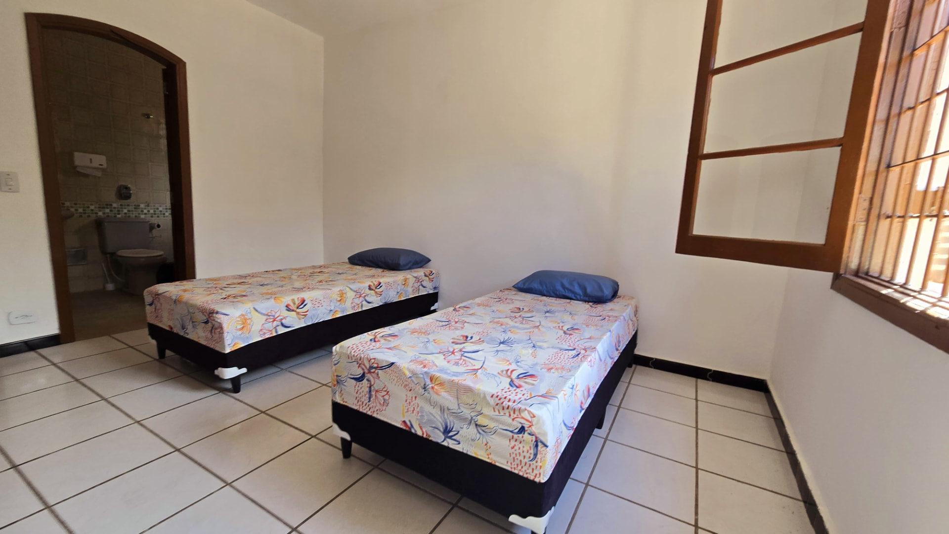 Quarto com TV e saída para o jardim